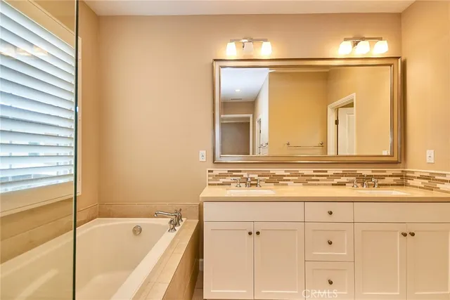 a bathroom with a tub a shower and a sink