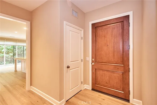 a view of a livingroom with wooden floor and a hallway