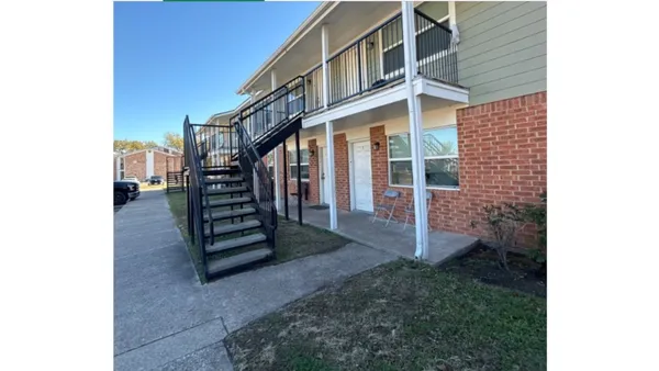 a view of a house with a small yard and stairs