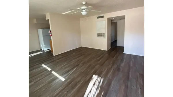 a view of an empty room with wooden floor