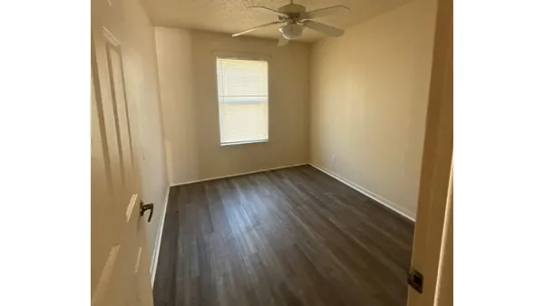 a view of a room with wooden floor and a window
