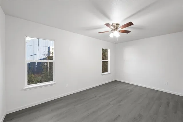 a view of an empty room with a window and a ceiling fan