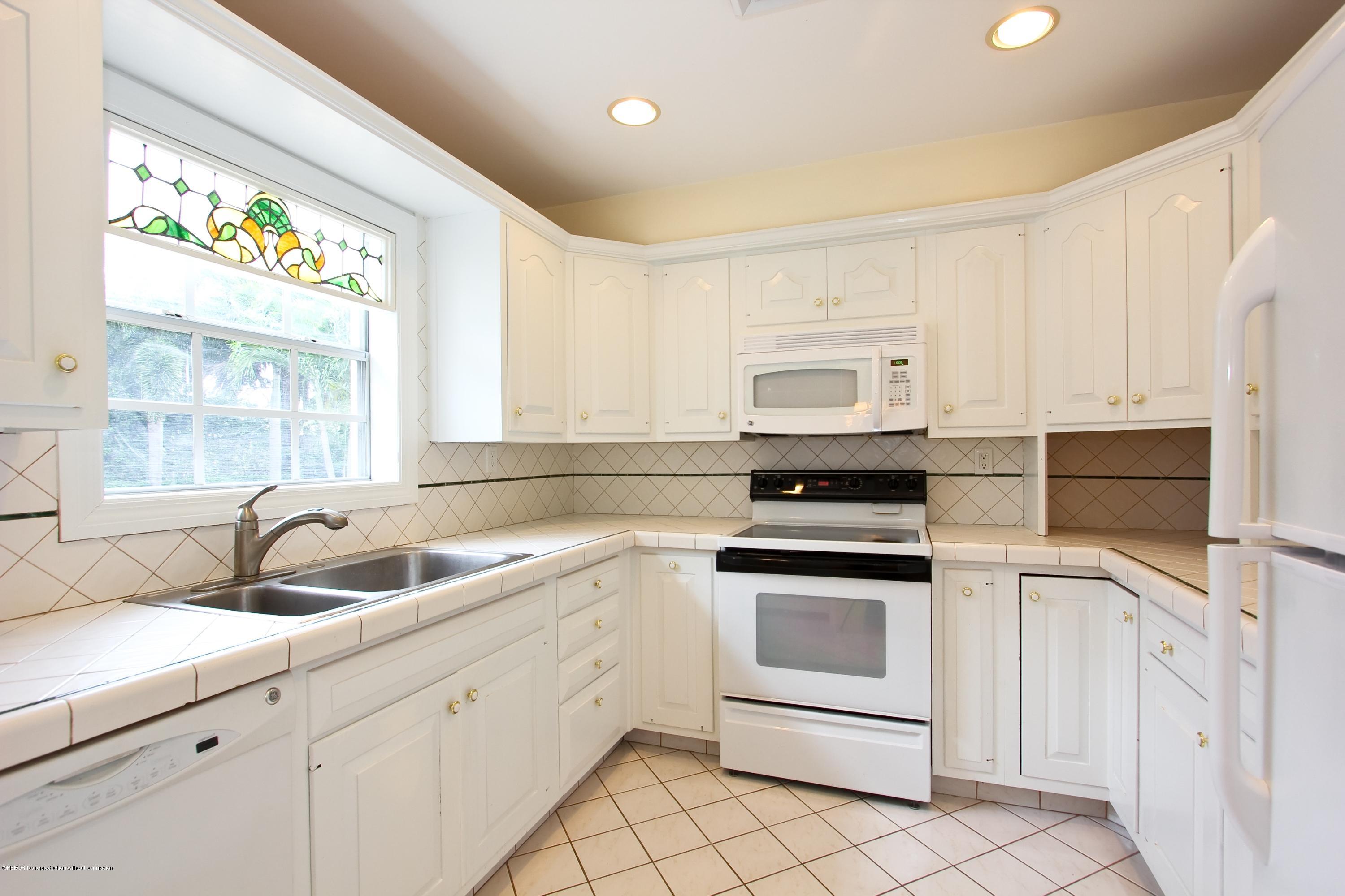 7312 Washington Road West Palm Beach, FL 33405 - Photo 5 of 10 a kitchen with white cabinets appliances and a sink