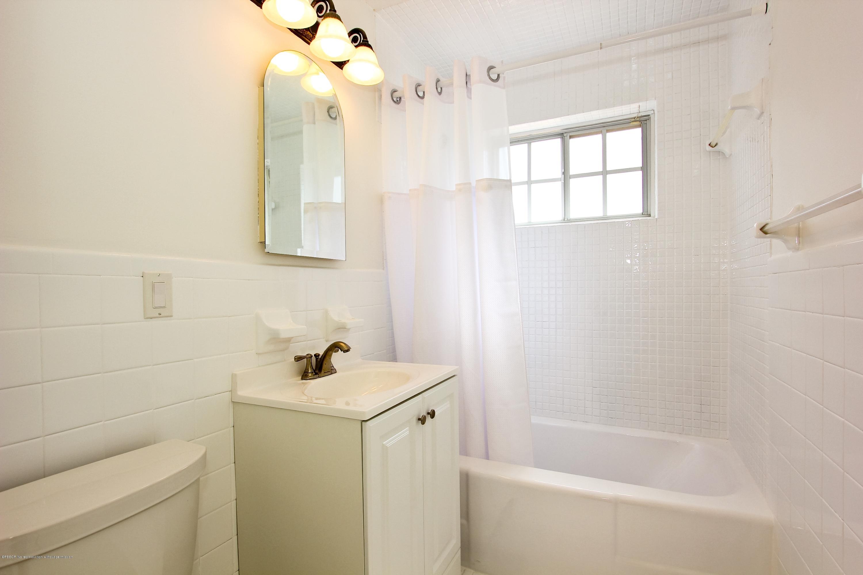 7312 Washington Road West Palm Beach, FL 33405 - Photo 6 of 10 a bathroom with a sink a toilet and shower