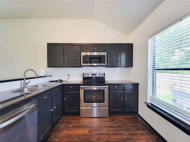 a kitchen with sink a stove and microwave
