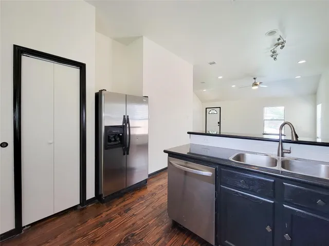 a kitchen with kitchen island a sink and refrigerator