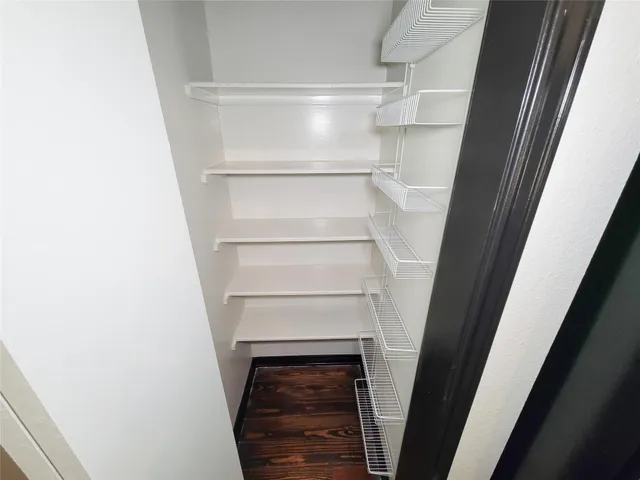 a view of walk in closet with empty racks
