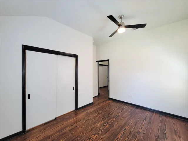 a view of a room with wooden floor and a ceiling fan