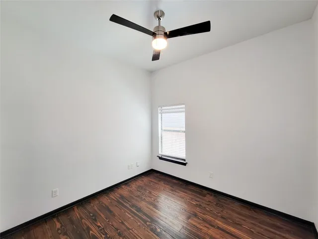 a view of a room with wooden floor and a ceiling fan