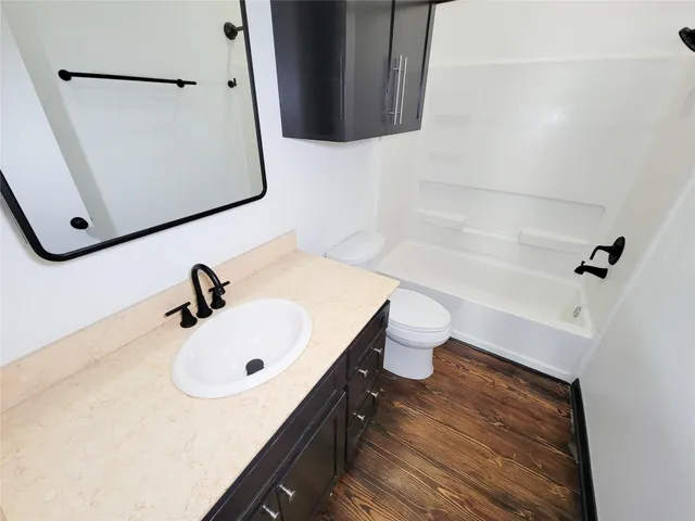 a bathroom with a sink toilet and mirror