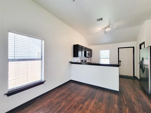 a kitchen with kitchen island wooden floor and window