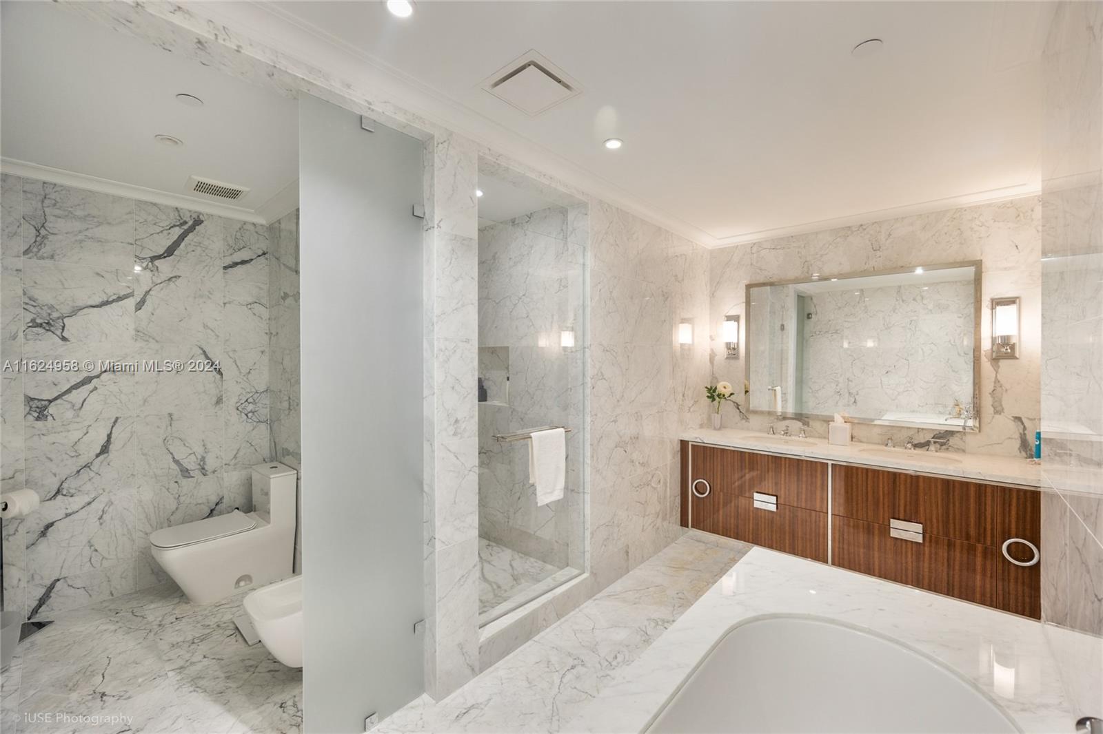 15701 Collins Avenue, Unit 4303 Sunny Isles Beach, FL 33160 - Photo 6 of 12 a spacious bathroom with a bathtub shower sink mirror and toilet