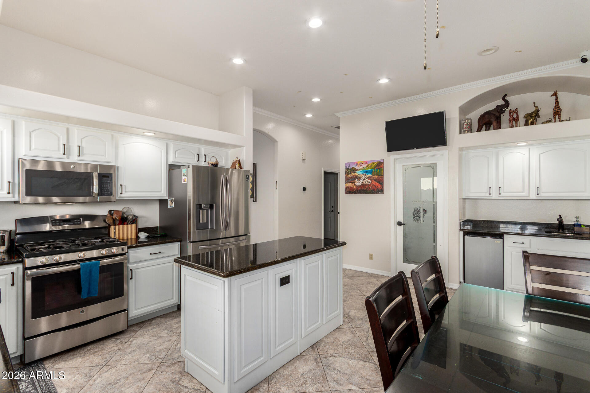 8912 North 15th Lane Phoenix, AZ 85021 - Photo 7 of 17 a kitchen with stainless steel appliances kitchen island granite countertop a stove and a refrigerator