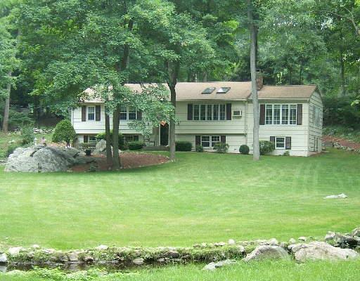 a aerial view of a house with a big yard and large trees