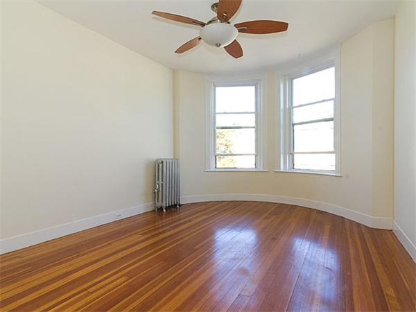 44 Orkney Road, Unit 5 Boston, MA 02135 - Photo 3 of 12 an empty room with wooden floor chandelier fan and windows