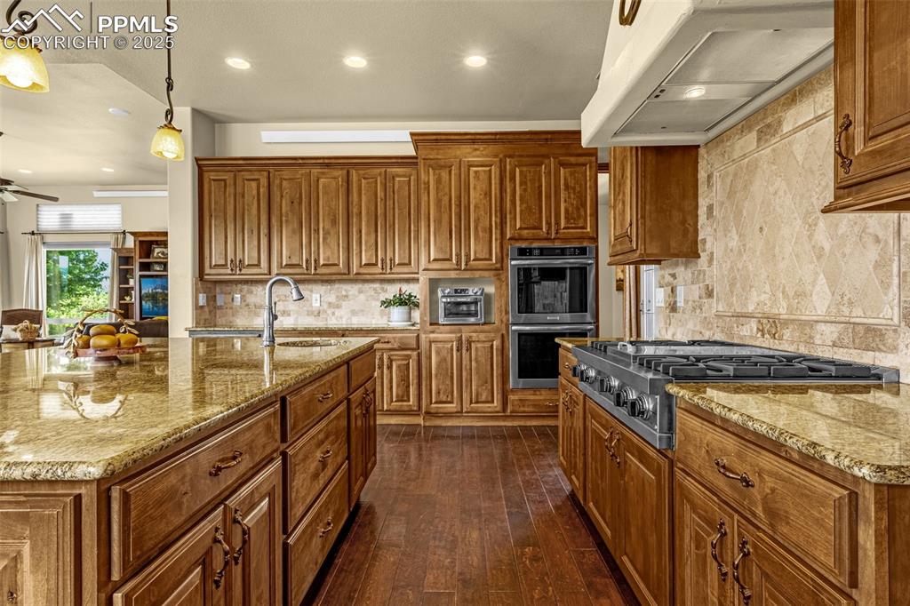 11784 Spruce Mountain Road Larkspur, CO 80118 - Photo 15 of 49 a kitchen with stainless steel appliances granite countertop a stove a sink and a refrigerator