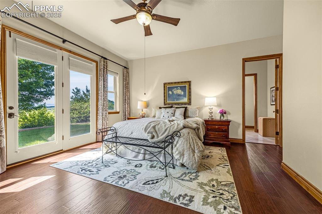 11784 Spruce Mountain Road Larkspur, CO 80118 - Photo 22 of 49 a bedroom with furniture bed and wooden floor