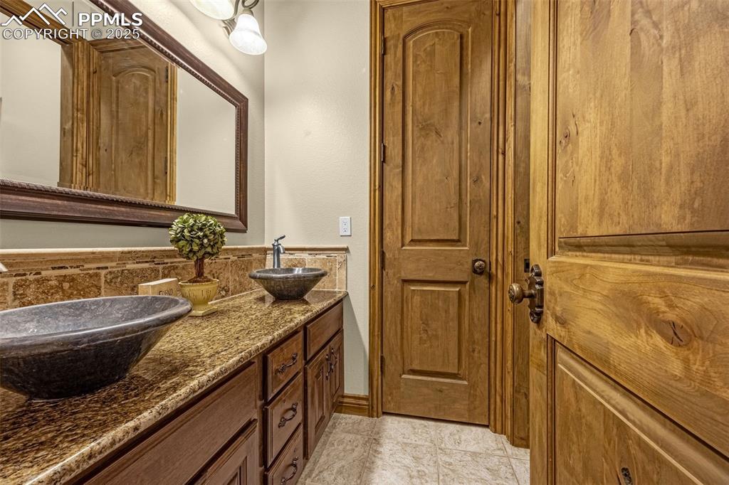 11784 Spruce Mountain Road Larkspur, CO 80118 - Photo 29 of 49 a bathroom with a granite countertop sink and a mirror