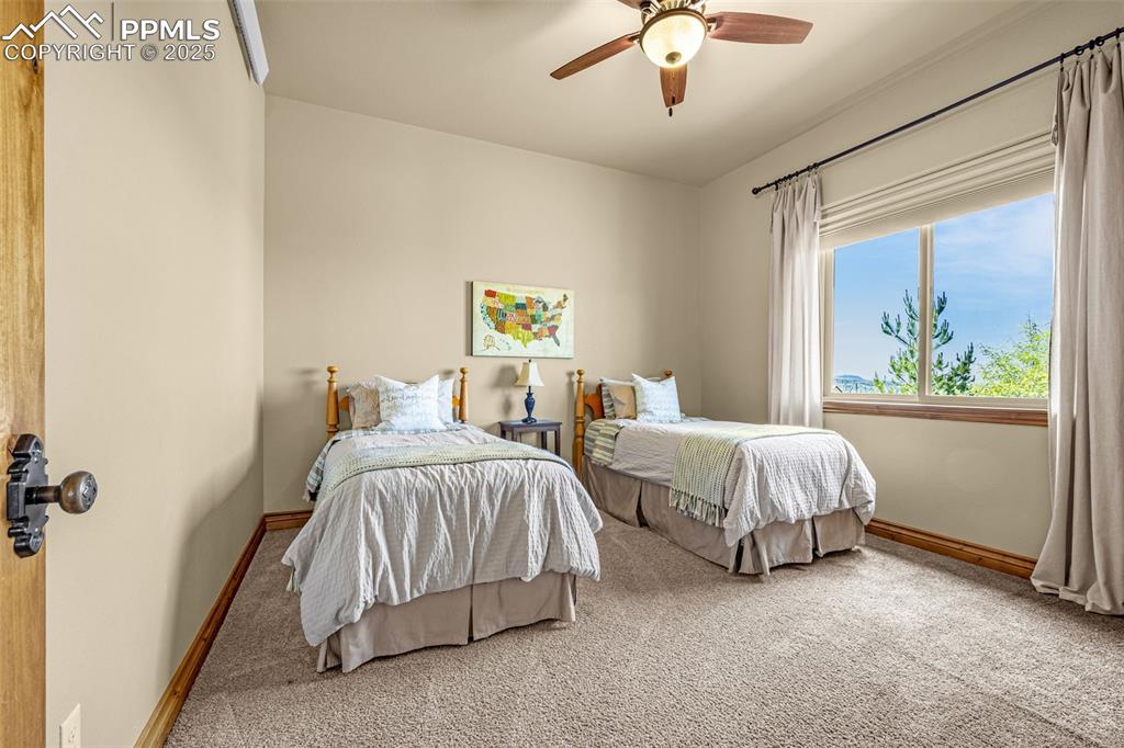 11784 Spruce Mountain Road Larkspur, CO 80118 - Photo 31 of 49 a bedroom with two beds and a chandelier