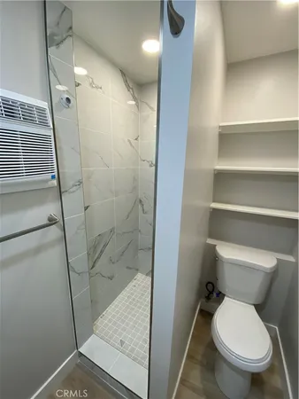 a white toilet sitting next to a shower