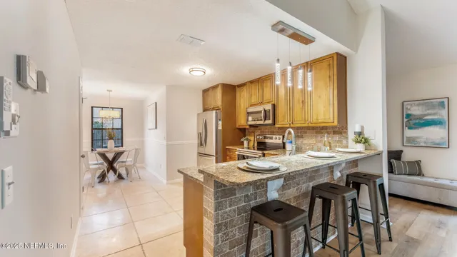 a view of a a dining table chairs and chandelier