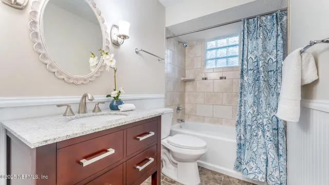 a bathroom with a granite countertop sink a toilet and shower