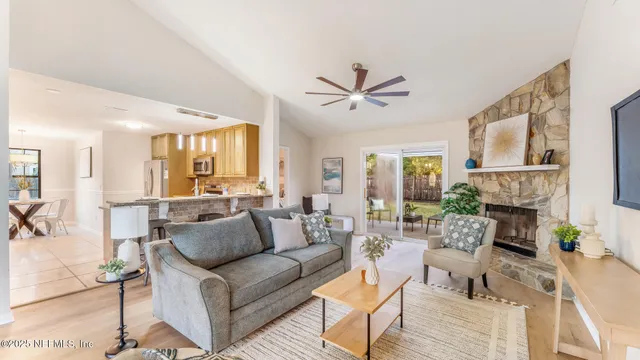a living room with furniture a fireplace and a large window