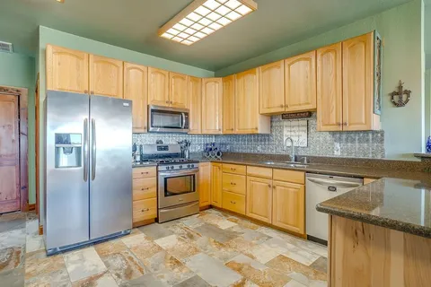 a kitchen with stainless steel appliances granite countertop a refrigerator sink and cabinets
