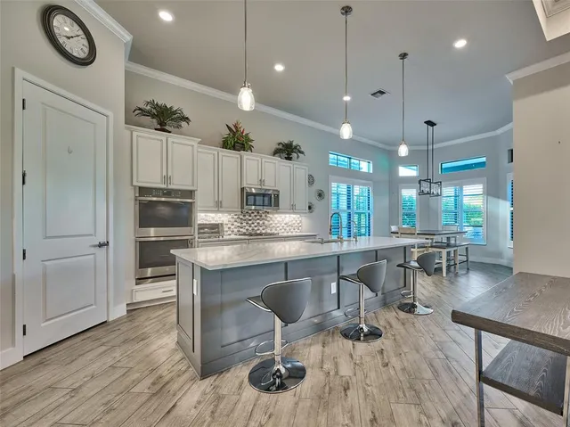 a dining room with wooden floor a chandelier a wooden table and chairs