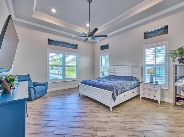 a bedroom with a large bed and a chandelier
