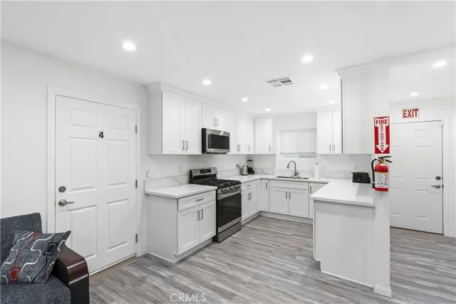 a kitchen with cabinets and wooden floor
