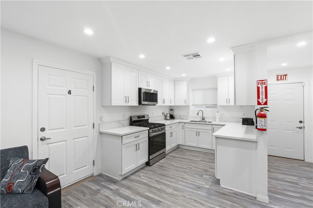 a kitchen with cabinets and wooden floor