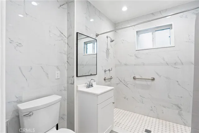 a bathroom with a sink a toilet and shower