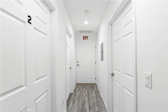 a view of a hallway with wooden floor and closet