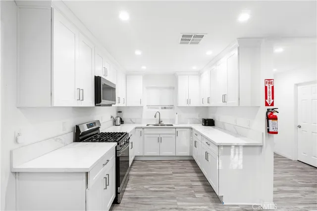 a kitchen with a sink a stove and cabinets