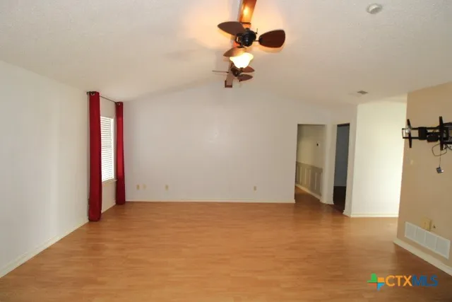 a view of an empty room with wooden floor