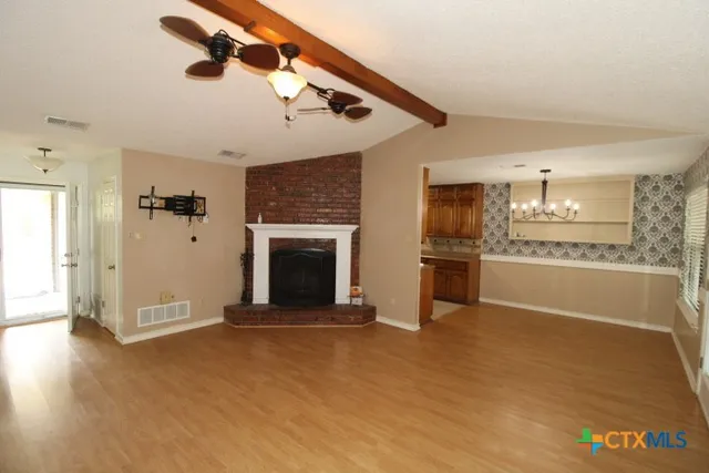 an empty room with windows and fireplace