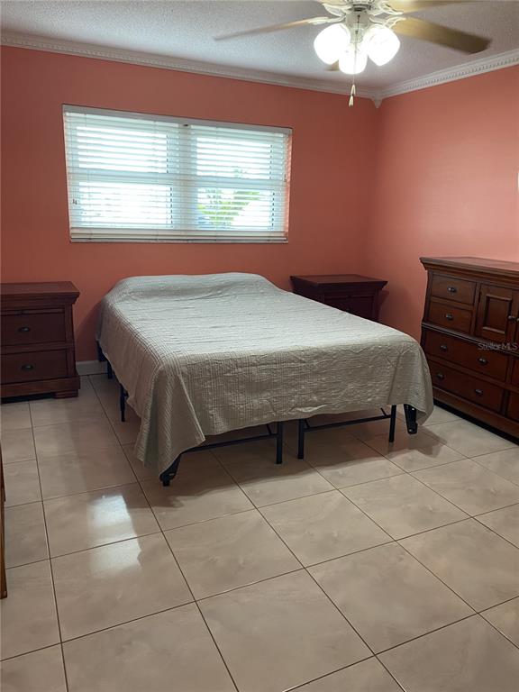 5555 Gulf Boulevard, Unit 104 St. Pete Beach, FL 33706 - Photo 11 of 35 a bedroom with a bed and a chandelier
