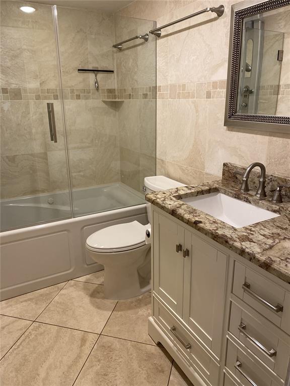 5555 Gulf Boulevard, Unit 104 St. Pete Beach, FL 33706 - Photo 13 of 35 a bathroom with a granite countertop sink toilet and shower