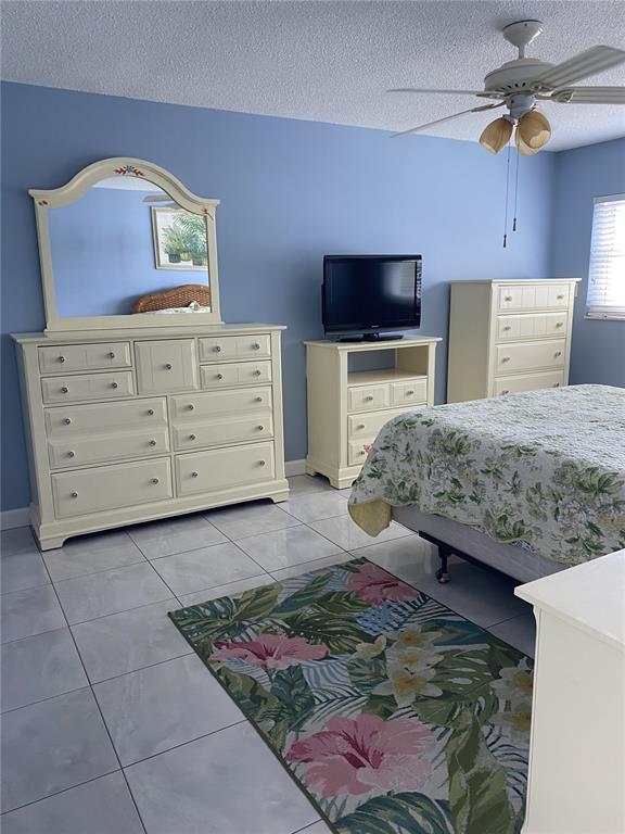 5555 Gulf Boulevard, Unit 104 St. Pete Beach, FL 33706 - Photo 15 of 35 a bedroom with a bed and a television