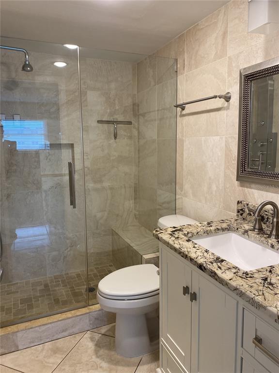 5555 Gulf Boulevard, Unit 104 St. Pete Beach, FL 33706 - Photo 18 of 35 a bathroom with a granite countertop sink a toilet and shower