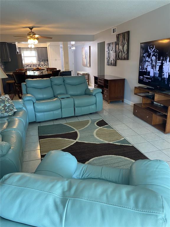 5555 Gulf Boulevard, Unit 104 St. Pete Beach, FL 33706 - Photo 2 of 35 a living room with furniture and a flat screen tv