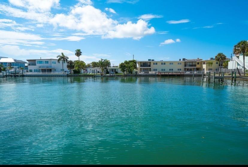 5555 Gulf Boulevard, Unit 104 St. Pete Beach, FL 33706 - Photo 22 of 35 a view of a ocean with boats and trees in the background