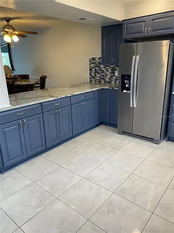 a kitchen with stainless steel appliances granite countertop a refrigerator and a sink