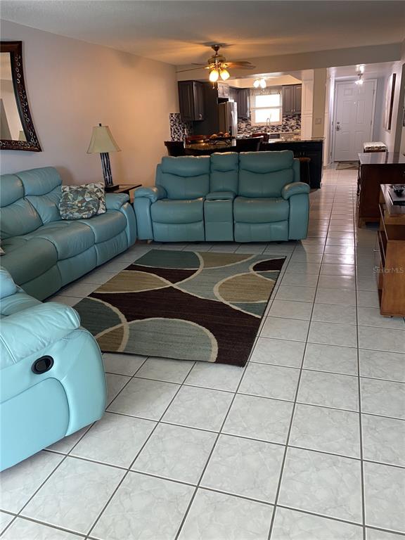 5555 Gulf Boulevard, Unit 104 St. Pete Beach, FL 33706 - Photo 8 of 35 a living room with furniture and a chandelier