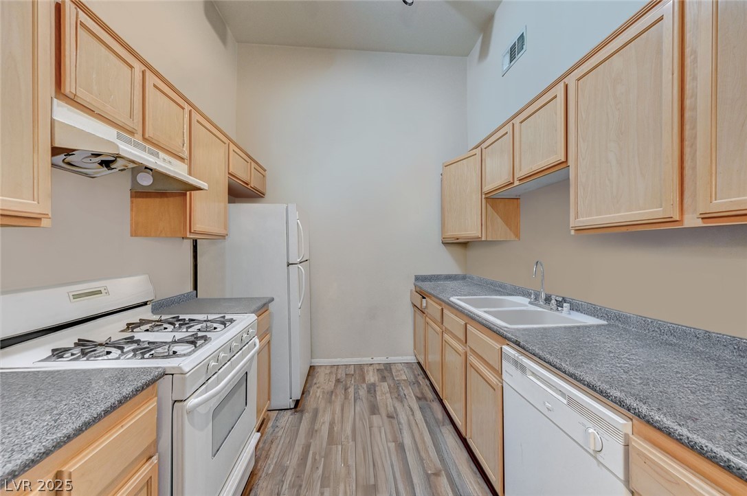 2305 West Horizon Ridge Parkway, Unit 1223 Henderson, NV 89052 - Photo 13 of 28 Kitchen with light wood finish cabinetry and white appliances
