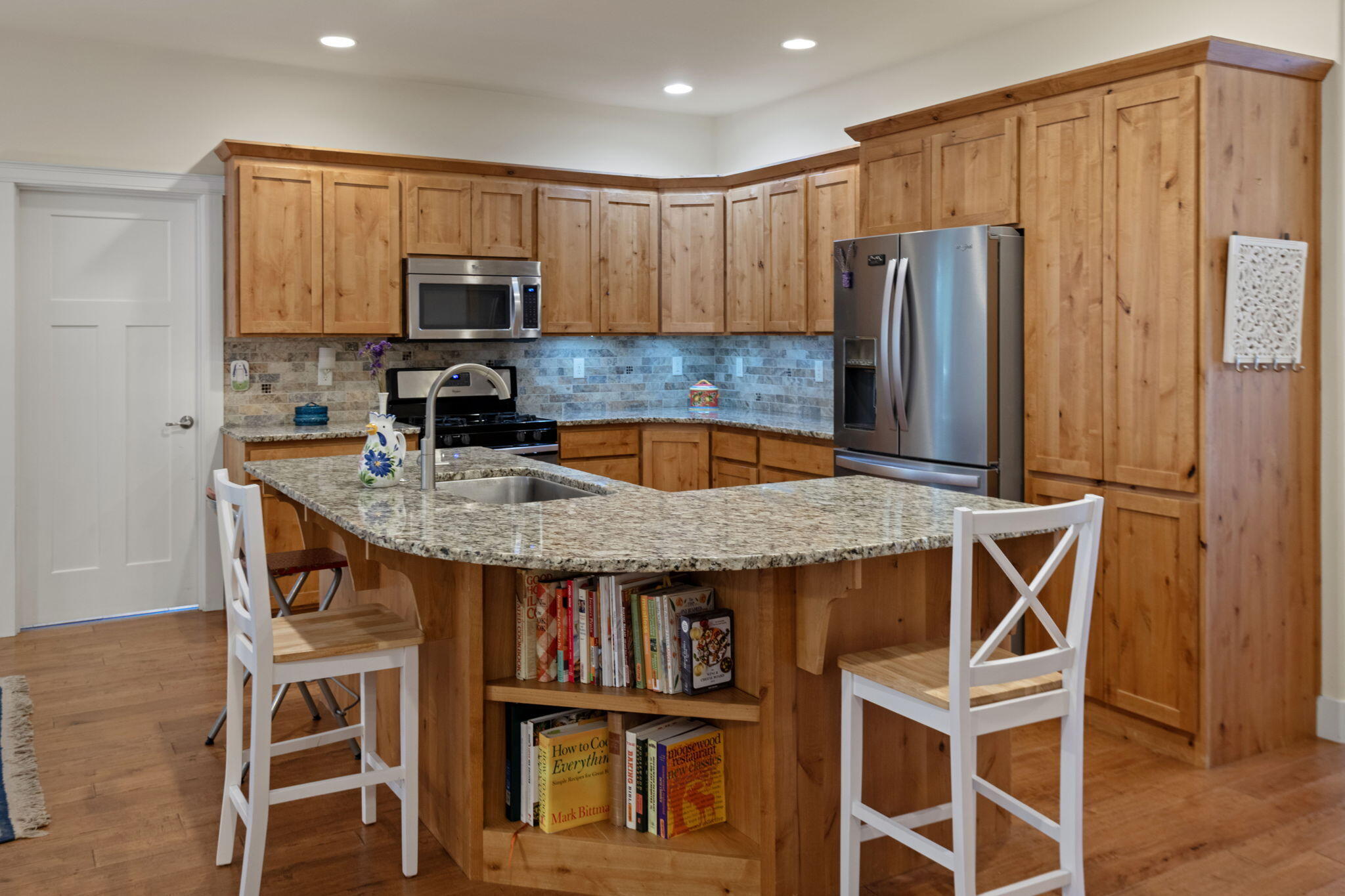 62944 Fresca Street Bend, OR 97703 - Photo 5 of 32 a kitchen with a table chairs refrigerator and microwave