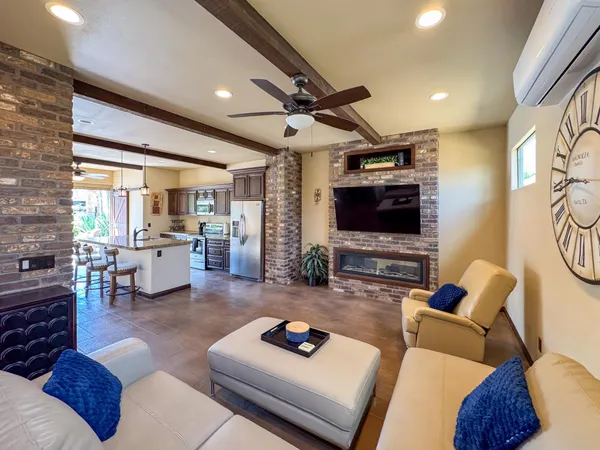 a living room with furniture and a flat screen tv with kitchen view