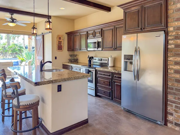 a kitchen with stainless steel appliances granite countertop a refrigerator and a stove top oven