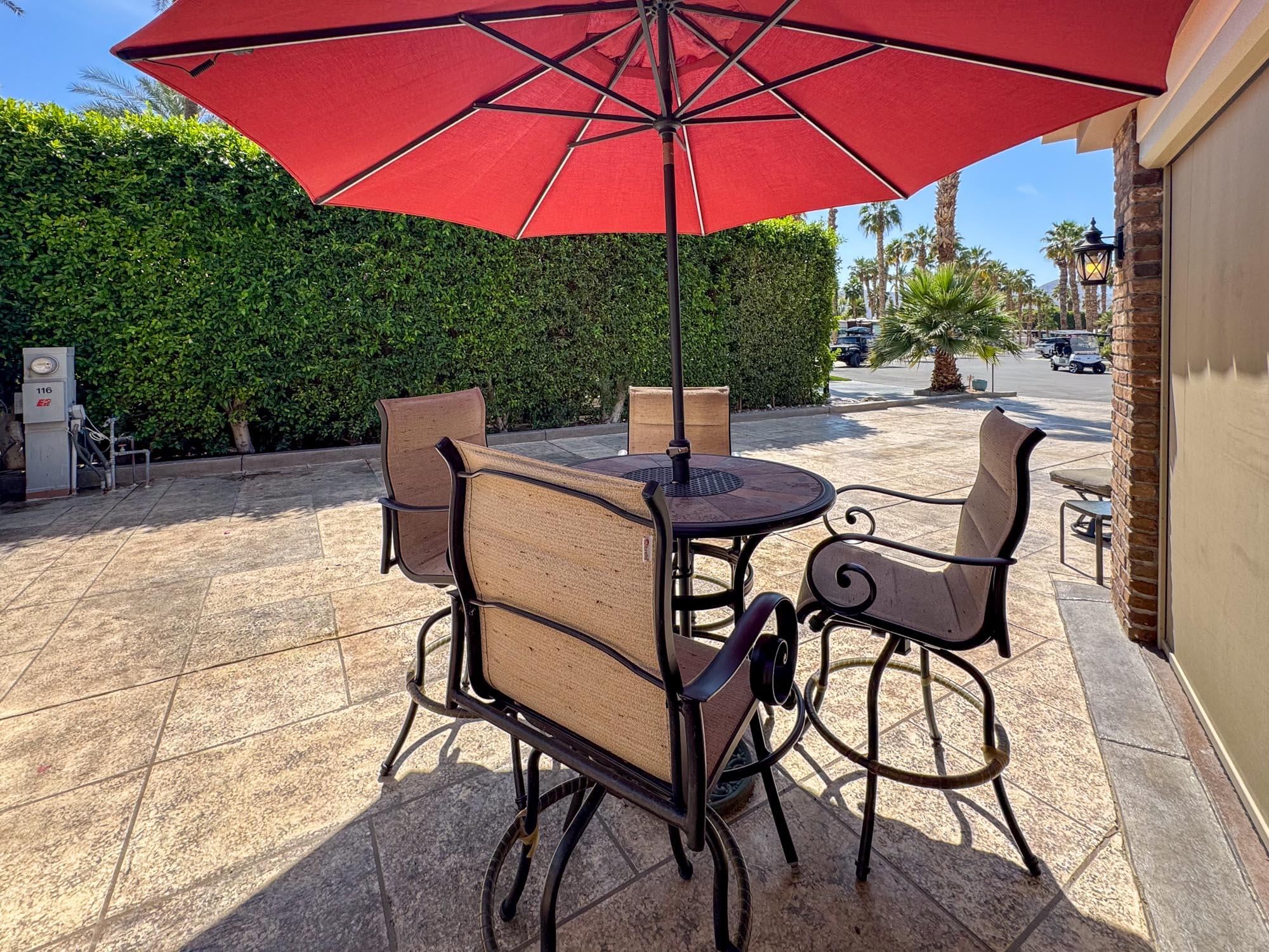 80394 Ave 48, Unit 116 Indio, CA 92201 - Photo 18 of 26 a patio with a table and chairs under an umbrella